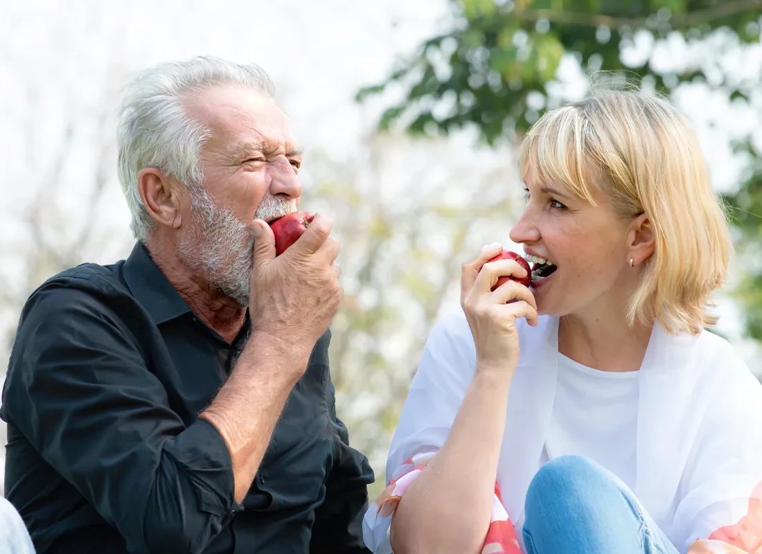 patient-biting-apple-after-implants.webp